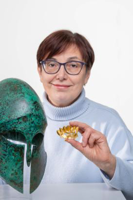 Brigitte Wormer, Mitarbeiterin des Museumspädagogischen Zentrums München, präsentiert die Brosche von Irene Griegst Kriegerhelm, Bronze, um 500 v. Chr., Antikensammlungen © Klaus Haag